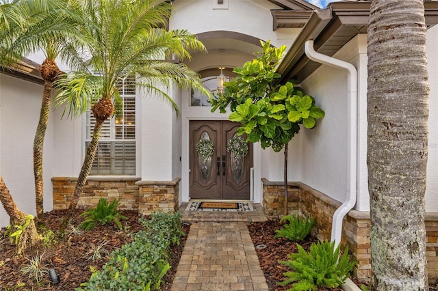 entrance to property with stone siding and stucco siding