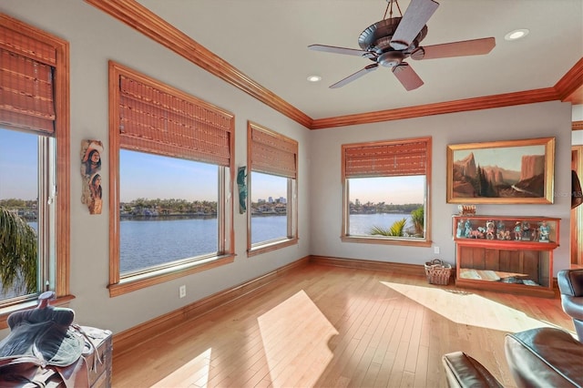 interior space with crown molding, light wood-type flooring, and a water view