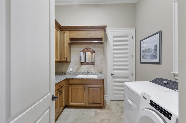 washroom with cabinets, sink, and washing machine and clothes dryer