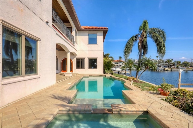 view of pool with a patio and a water view