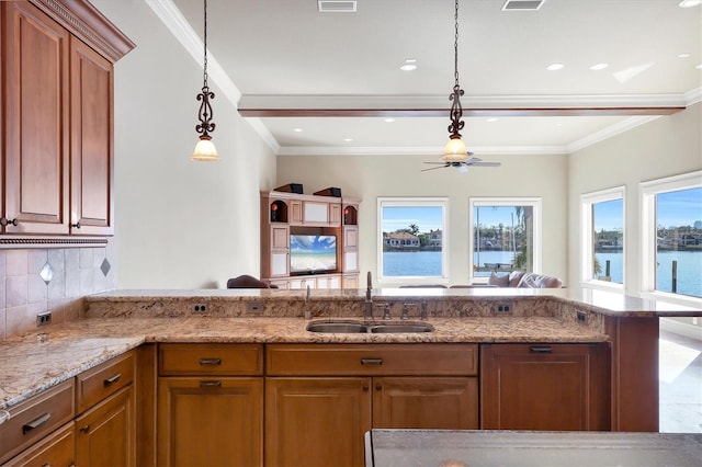 kitchen with decorative backsplash, ornamental molding, sink, and hanging light fixtures