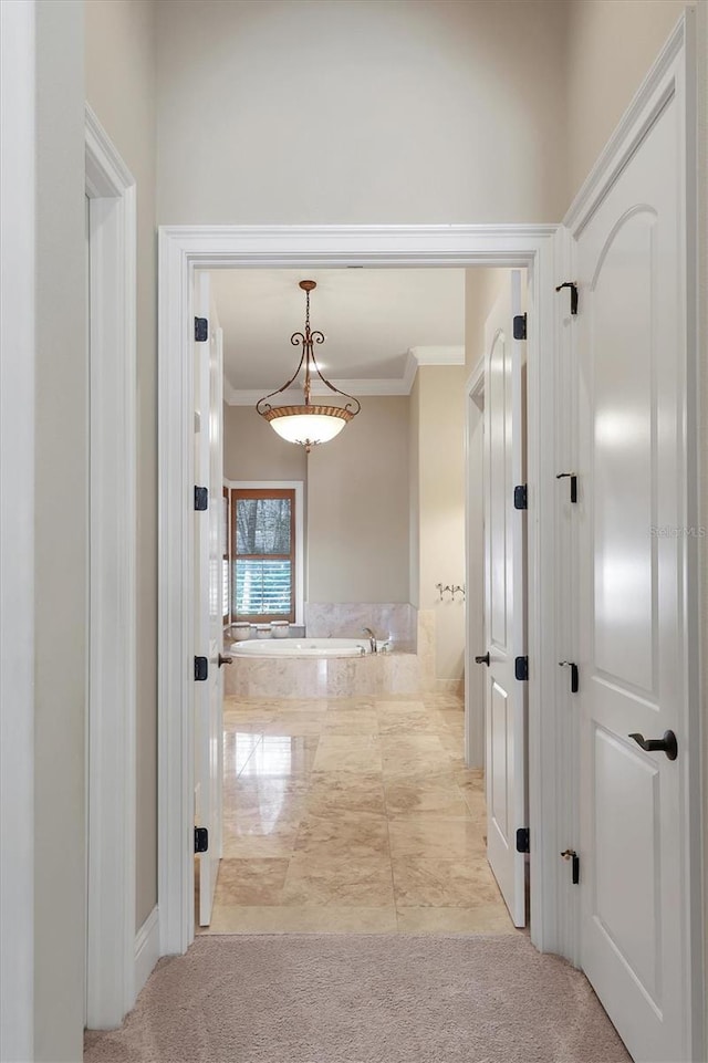 hallway featuring crown molding and light colored carpet