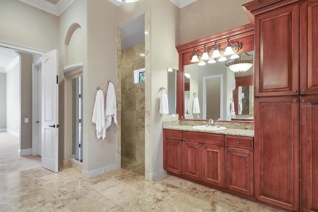 bathroom with vanity, tiled shower, and ornamental molding