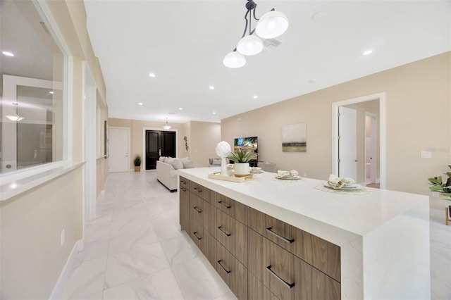 kitchen featuring a large island and decorative light fixtures