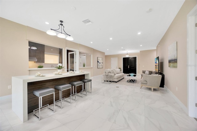 kitchen featuring a notable chandelier, decorative light fixtures, and a kitchen breakfast bar