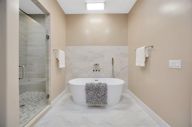 bathroom featuring plus walk in shower and tile walls