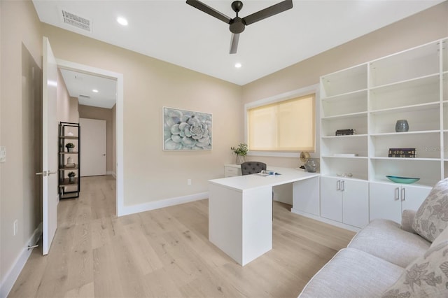 office featuring built in desk, ceiling fan, and light wood-type flooring