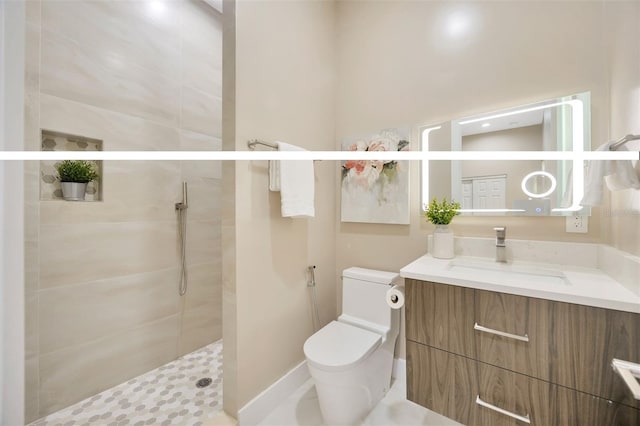 bathroom featuring vanity, a shower with shower door, and toilet