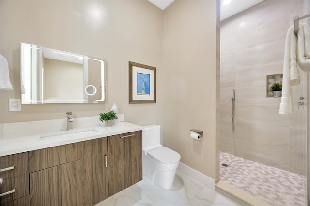 bathroom with vanity, toilet, and tiled shower