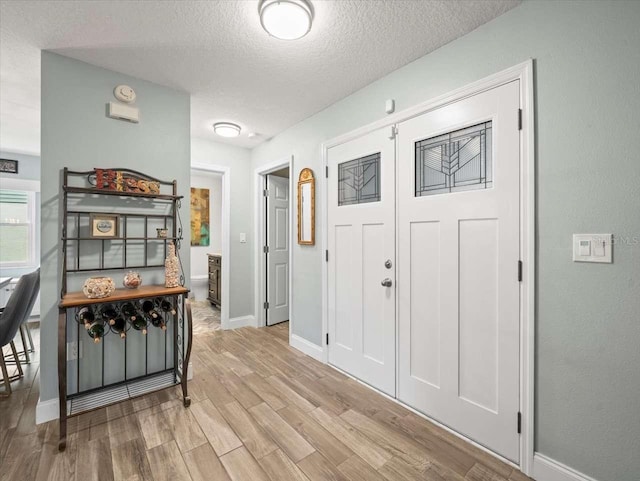 entrance foyer with a textured ceiling and light wood-type flooring