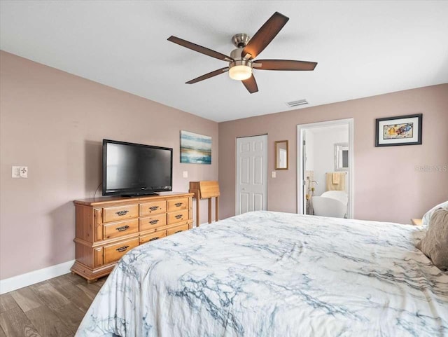 bedroom with hardwood / wood-style floors, ceiling fan, and ensuite bath