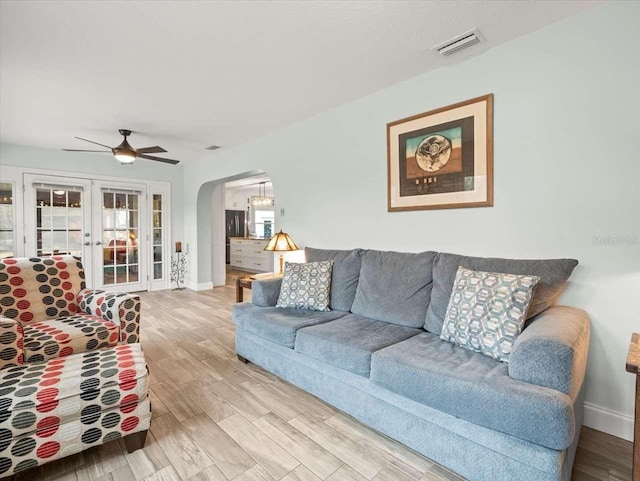 living room featuring hardwood / wood-style flooring, ceiling fan, and french doors