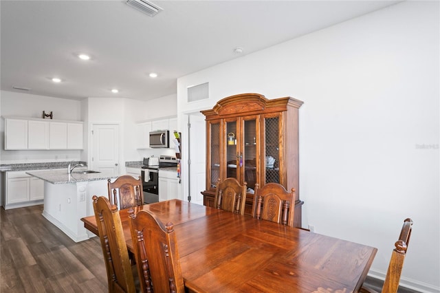 dining room with sink and dark hardwood / wood-style flooring