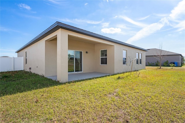 back of house with a patio and a yard