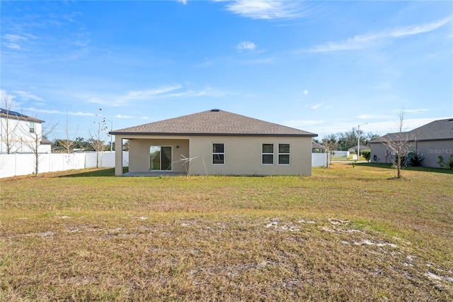 rear view of house featuring a yard