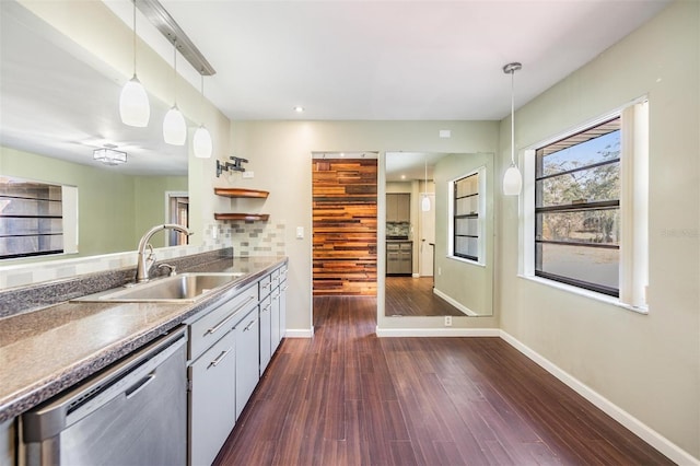 kitchen featuring pendant lighting, sink, backsplash, dark hardwood / wood-style flooring, and stainless steel dishwasher