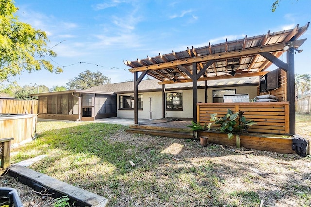 rear view of property with a sunroom, a yard, and a deck