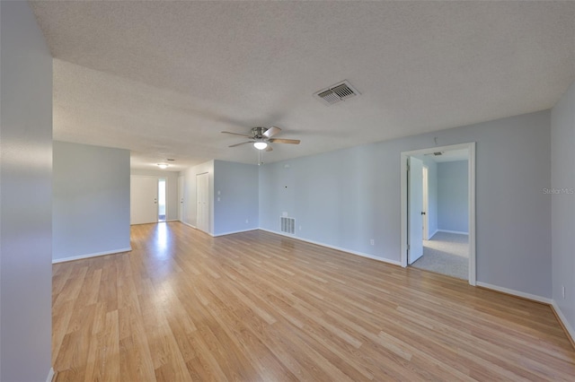 empty room with ceiling fan, a textured ceiling, and light hardwood / wood-style floors