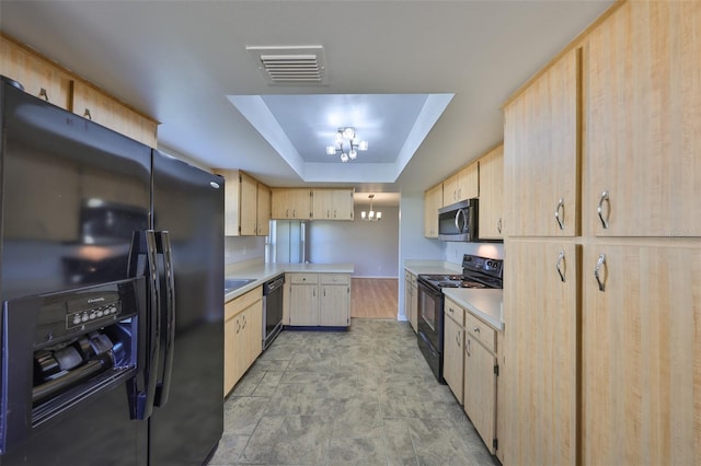 kitchen featuring a raised ceiling, light brown cabinets, an inviting chandelier, and black appliances