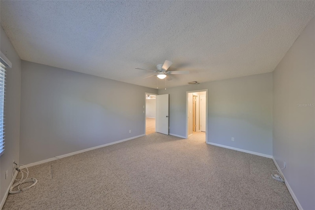 spare room featuring light colored carpet, a textured ceiling, and ceiling fan