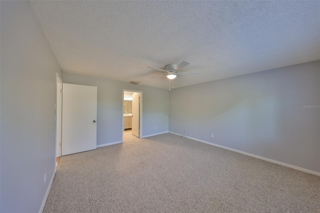 unfurnished room with ceiling fan, light carpet, and a textured ceiling