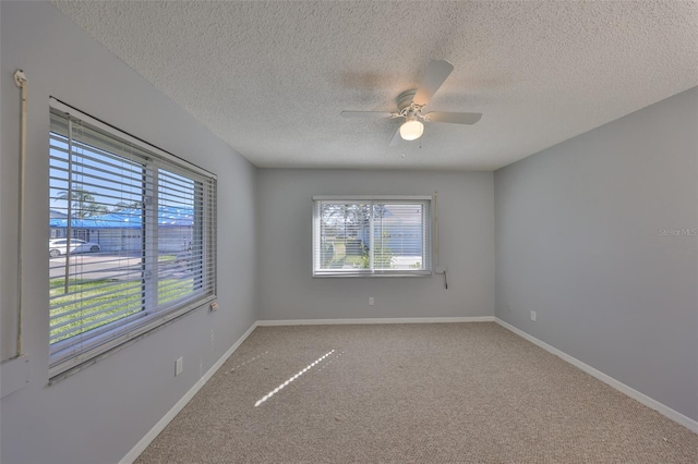 carpeted empty room with ceiling fan and a textured ceiling