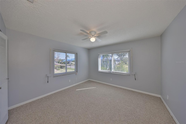 carpeted empty room with a textured ceiling and ceiling fan