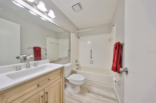 full bathroom with hardwood / wood-style flooring, tiled shower / bath, vanity, and toilet