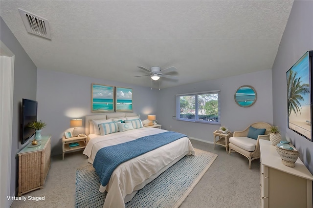 bedroom featuring ceiling fan, light colored carpet, and a textured ceiling