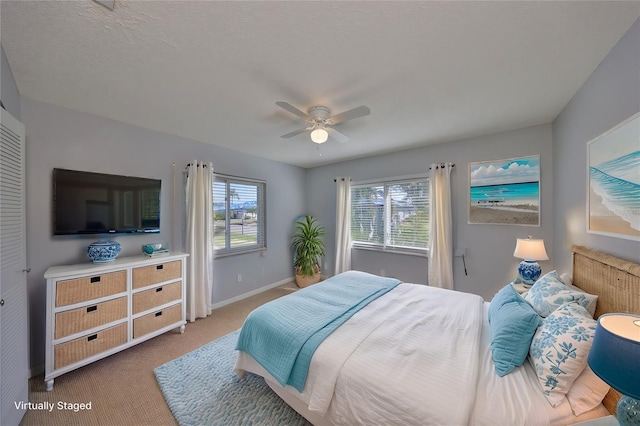 bedroom featuring carpet flooring, a textured ceiling, and ceiling fan