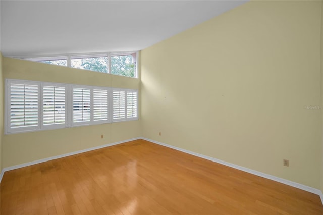 empty room with lofted ceiling and wood-type flooring