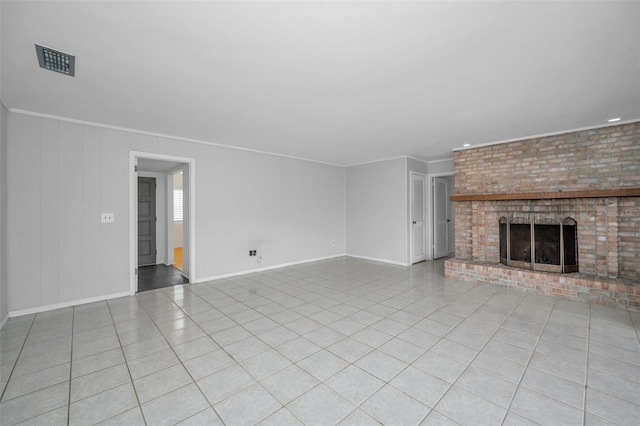 unfurnished living room featuring crown molding, a brick fireplace, and light tile patterned floors