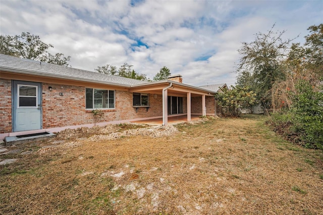 rear view of house featuring a yard and a patio area