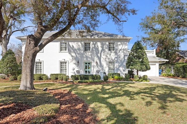 colonial house featuring a garage and a front lawn