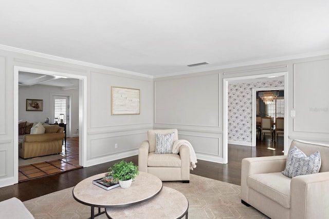 sitting room featuring crown molding, a chandelier, and hardwood / wood-style floors