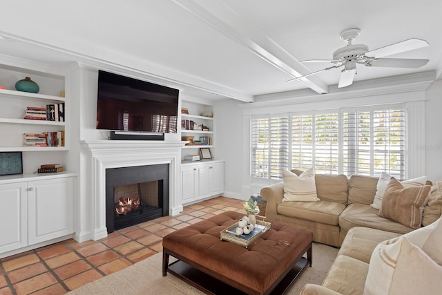 tiled living room with beamed ceiling, ceiling fan, and built in shelves