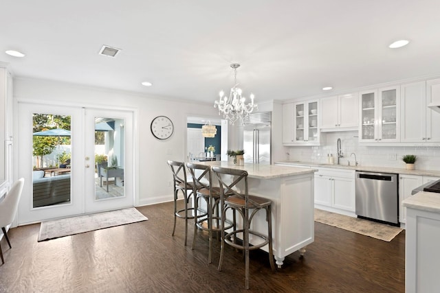 kitchen featuring white cabinetry, appliances with stainless steel finishes, sink, and decorative light fixtures