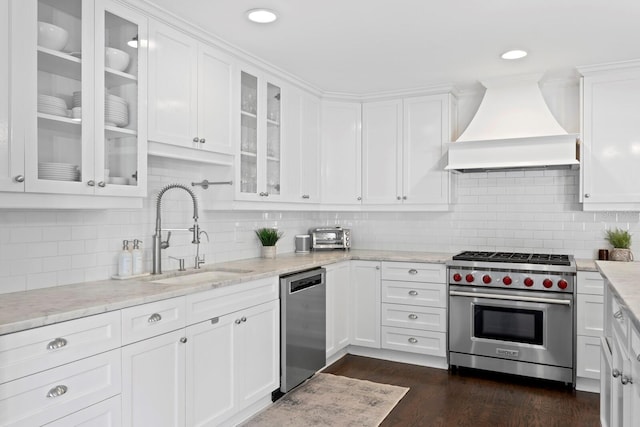 kitchen featuring stainless steel appliances, premium range hood, sink, and white cabinets