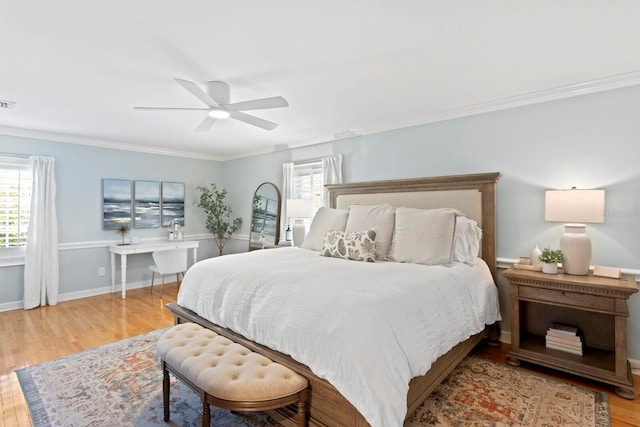 bedroom with light hardwood / wood-style flooring, ornamental molding, and ceiling fan