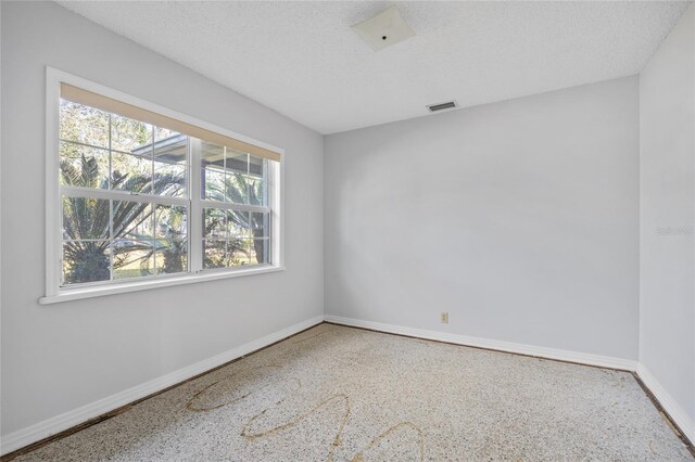 unfurnished room featuring a textured ceiling