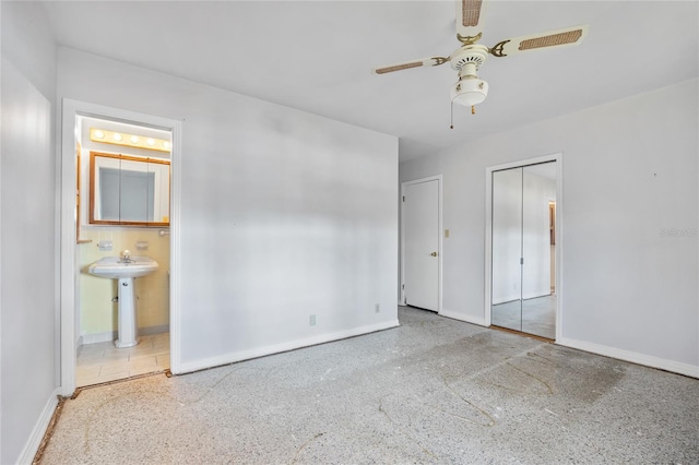 unfurnished bedroom featuring ceiling fan and ensuite bath