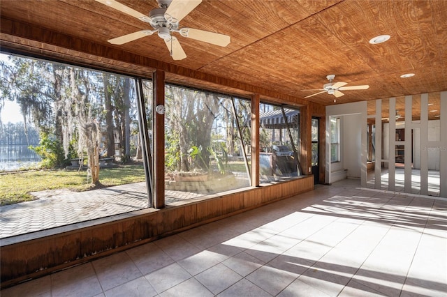 unfurnished sunroom with wood ceiling and ceiling fan