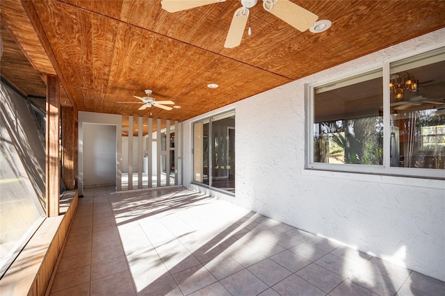 unfurnished sunroom featuring wood ceiling and ceiling fan