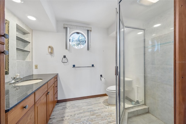 bathroom with a shower with door, vanity, and toilet