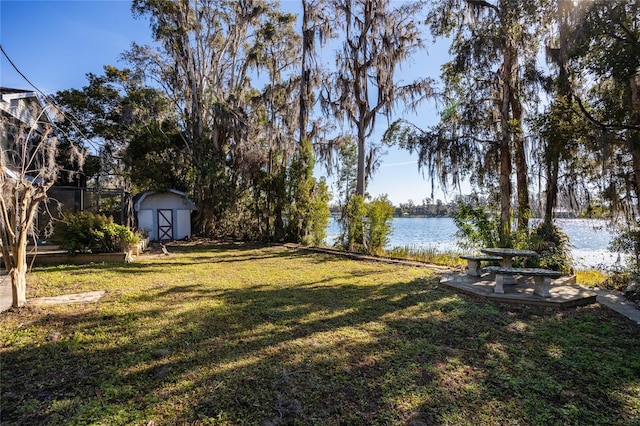 view of yard with a water view and a storage unit