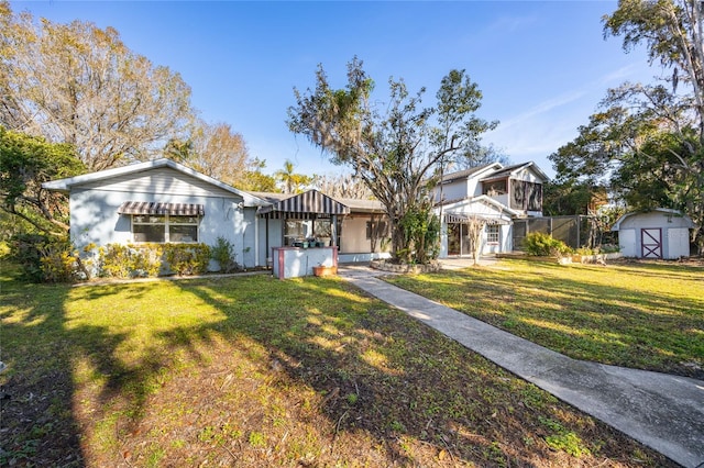 view of front of house featuring a front yard and a storage unit