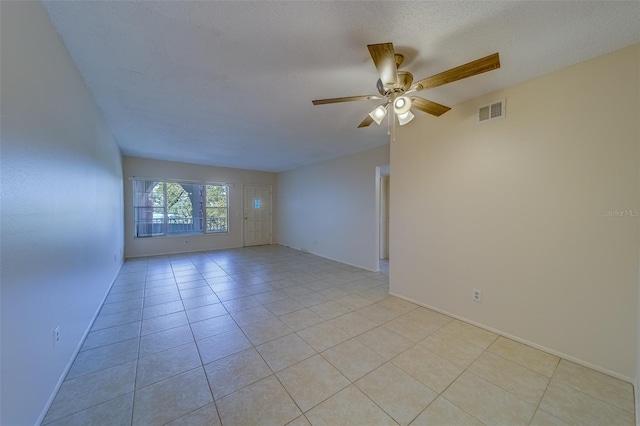 tiled spare room with a textured ceiling and ceiling fan