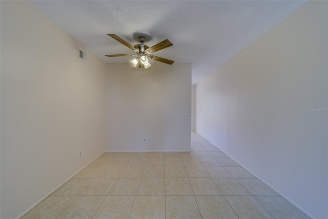 spare room featuring ceiling fan, a textured ceiling, and light tile patterned floors