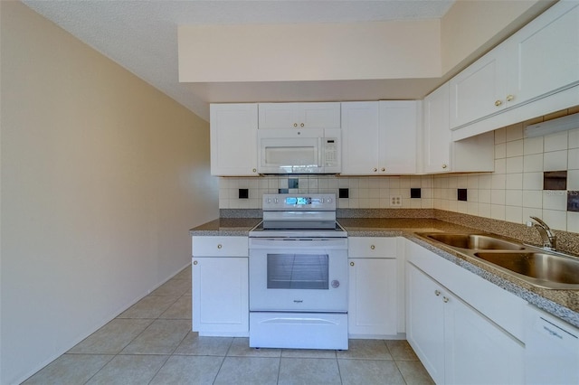 kitchen featuring sink, light tile patterned floors, white cabinets, and white appliances