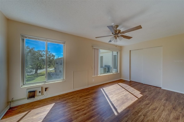 unfurnished bedroom with hardwood / wood-style flooring, a closet, and a textured ceiling